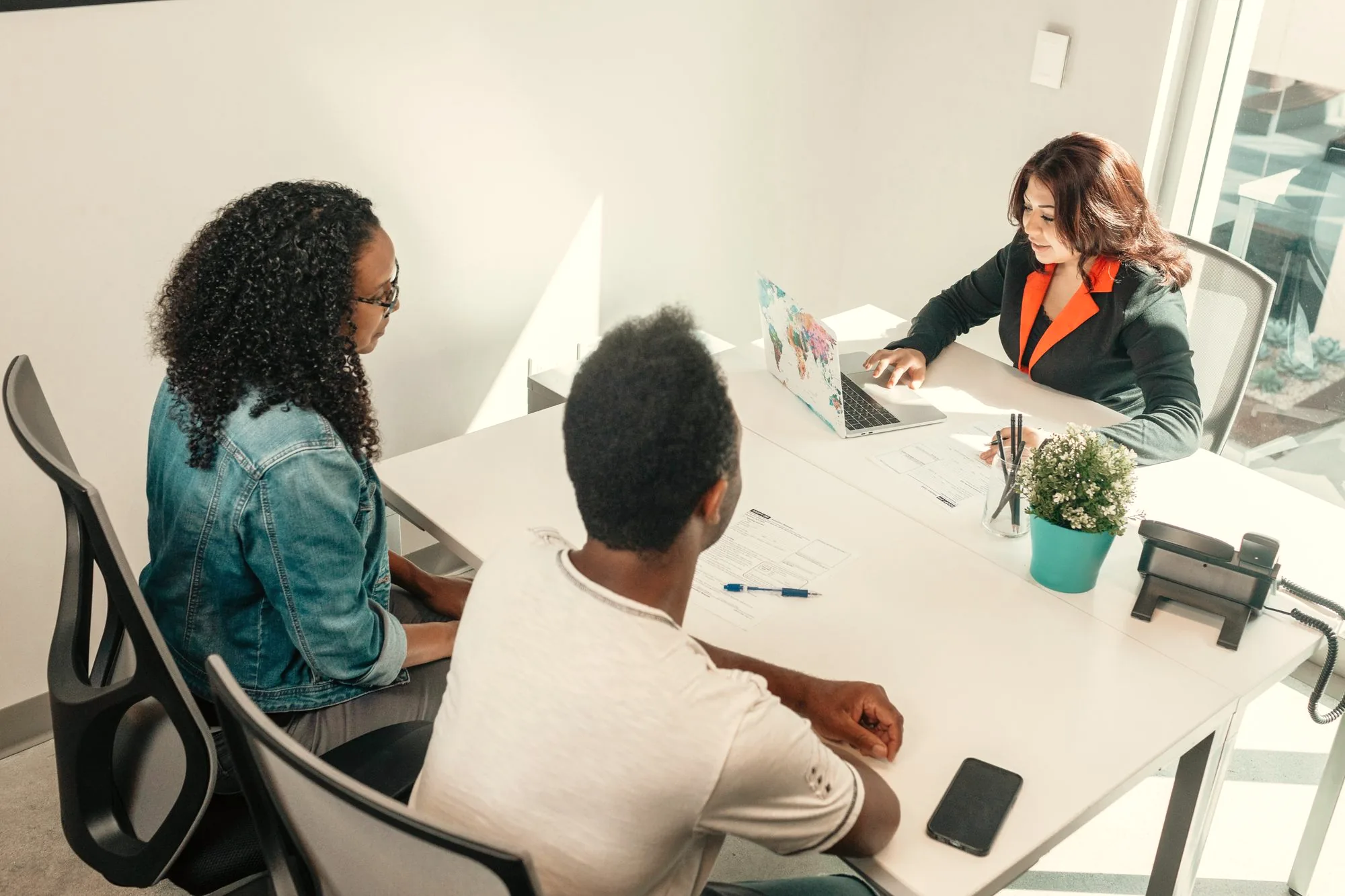 Three colleagues reviewing documents together at a table