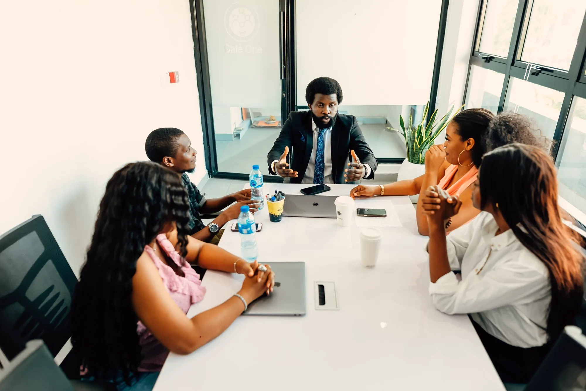 African business team in a meeting around a white table in a bright office