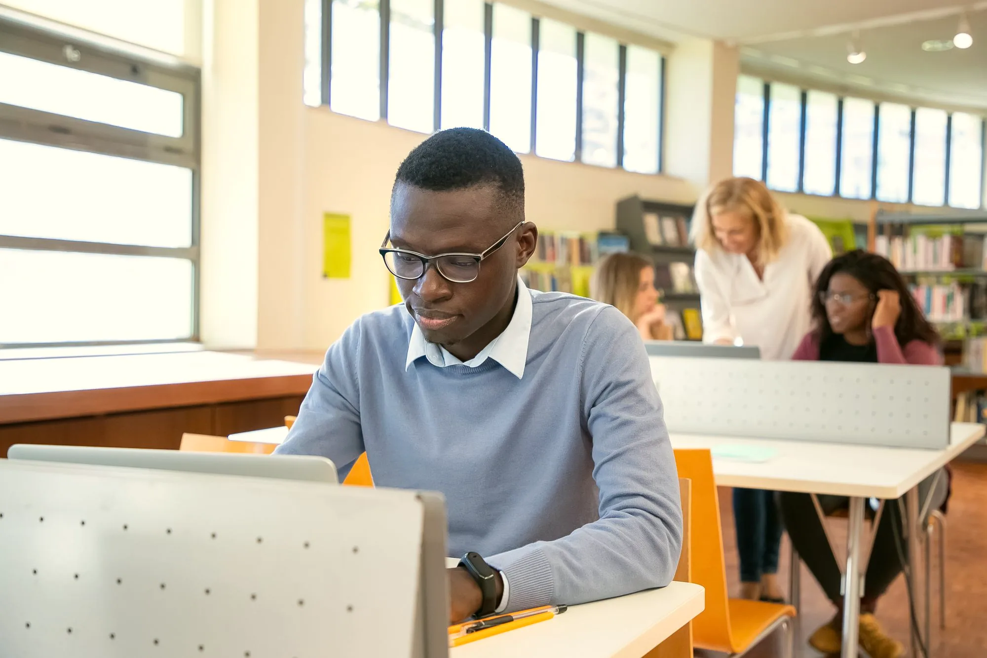 Students working on laptops in a library