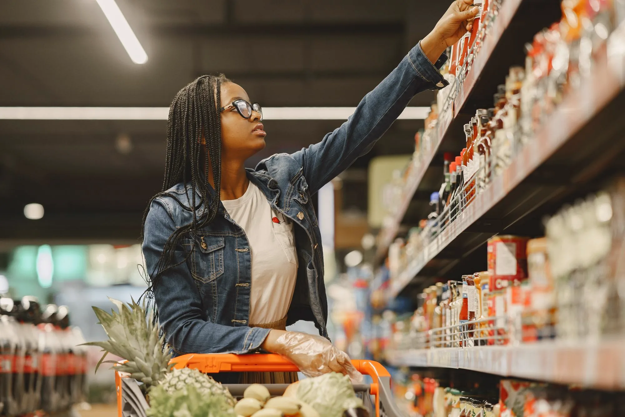 Shopper with a trolley in a supermarket aisle