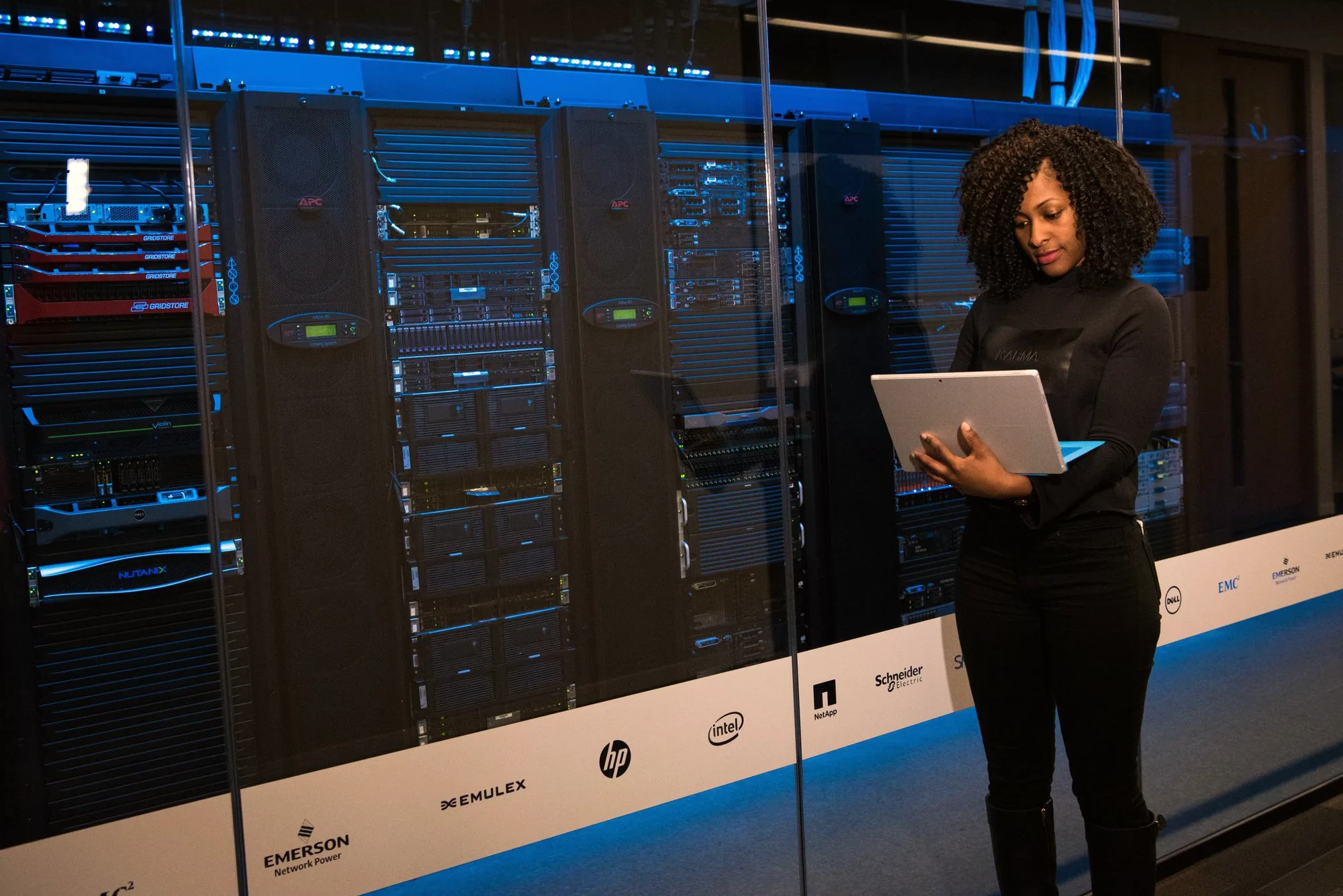 Female engineer with a laptop in a data-centre aisle