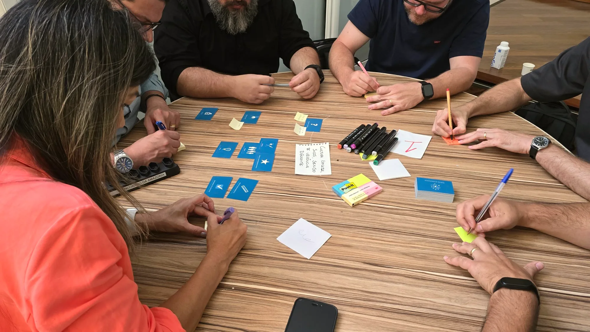 Hands arranging planning cards and sticky notes on a table