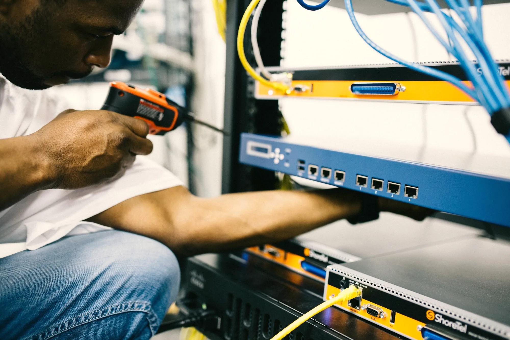 Technician hands connecting network hardware in a server rack