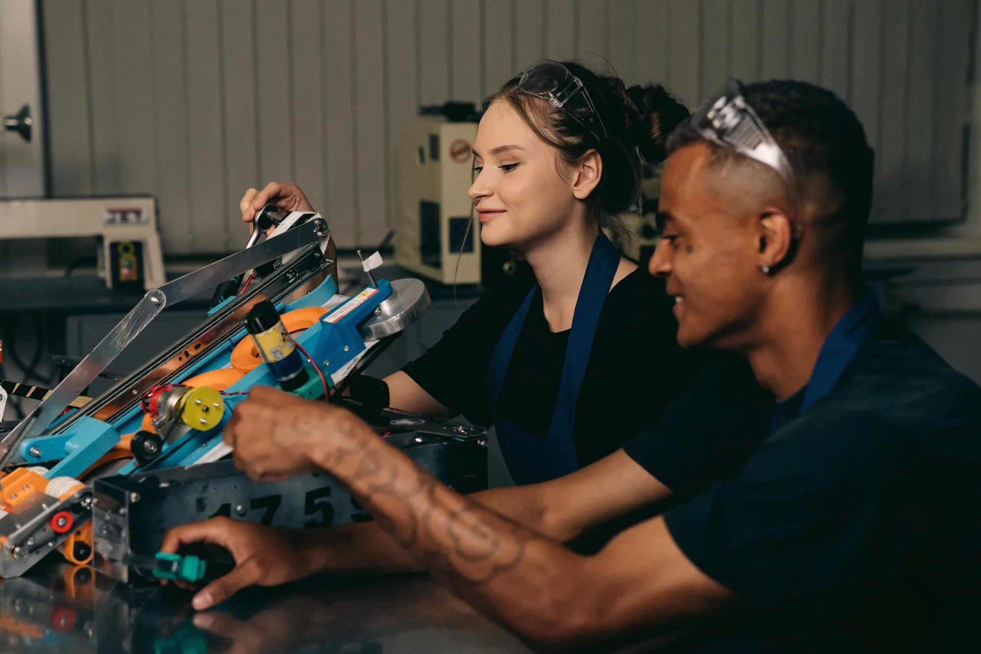 Two engineers building a robot together in a workshop